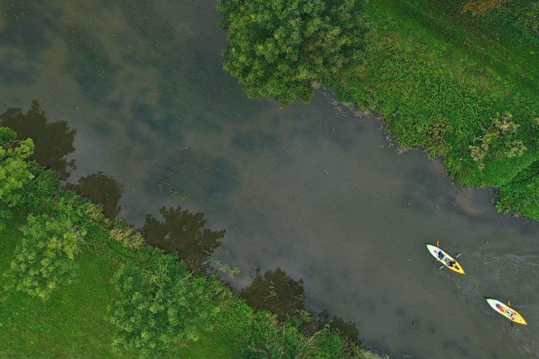 Zwei Kajaks auf der Altmühl und der Himmel spiegelt sich auf der Wasseroberfläche