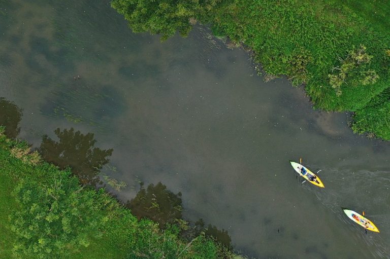 Zwei Kajaks von oben und der Himmel spiegelt sich im Fluss